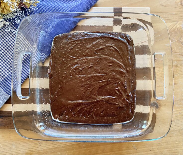 glass pan of brownie batter ready to be baked